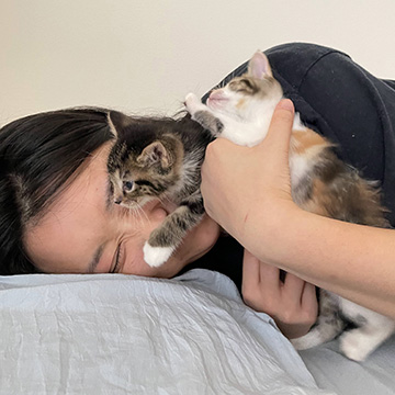 Ann Kan holding two kittens
